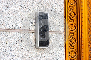 Black metal electric code lock with the digital keypad and card access near the house entrance door.