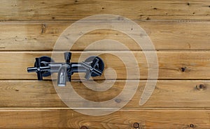 Black metal faucet on a wooden background. Mixer tap in the bathroom