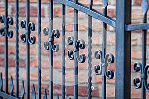 Black metal fence with the brick wall in the background