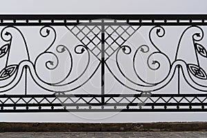 Black metal fence, closeup. Beautiful decorative cast iron wrought fence with artistic forging. Metal guardrail