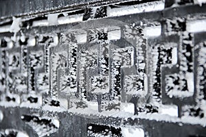 The black metal fence, covered with ice crystals