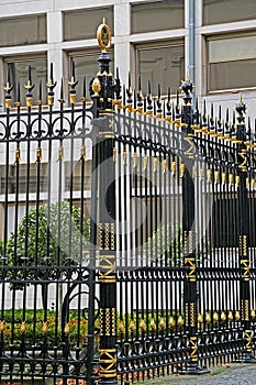 Black metal fence with golden ornaments