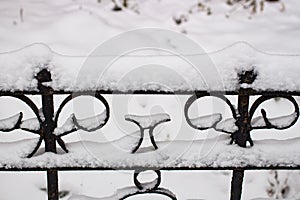 Black metal fence in the snow