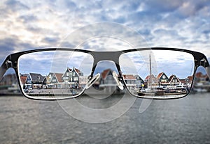 Black metal glasses looking through colorful cityscape photo