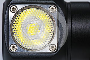 Black metal led headlamp flashlight with a lens close up. Anodized knurled aluminum grip