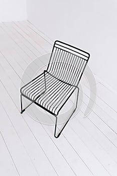 Black metal modern chair in empty white room