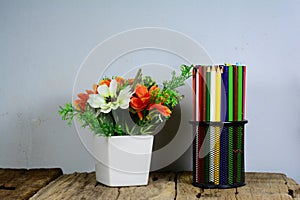 black metal pencil case and white vase on old wooden table