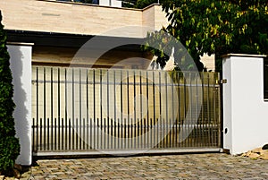 black metal picket gate and fence with transparent plastic sheet attached for privacy.