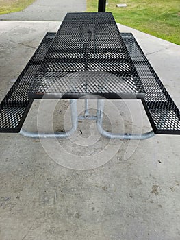 Black metal picnic table plane on cement floor
