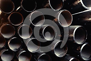 Black metal pipes and adapters of different diameters for gasification or water supply. Industrial background