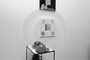 Black metal side table with matching teacups and decorative mirrors on the wall