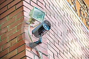 Black metal street security video camera on wall photo