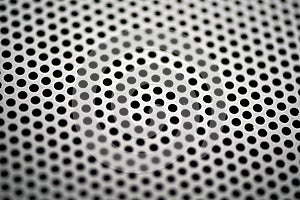 Black metal texture with round holes. Industrial background