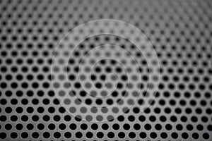 Black metal texture with round holes. Industrial background