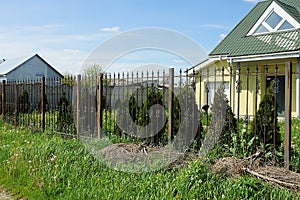 Black metal wall of a fence made of sharp iron rods outside