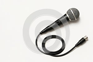Black microphone with cable on a light background. Space for text.