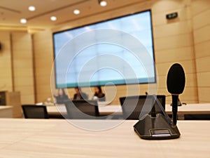 Black microphone in concert hall or conference meeting room or auditorium with defocused bokeh lights in background