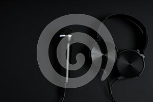 black microphone and headphones on a black background