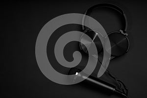 black microphone and headphones on a black background