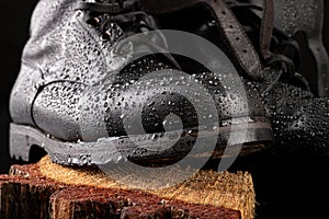 Black military boots and rain drops. Well-preserved old boots for soldiers