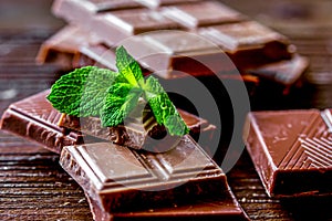 Black and milk chocolate bars dark wooden table background