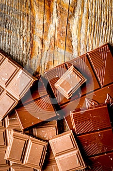 Black and milk chocolate bars dark wooden table background top view mockup