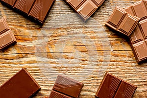 Black and milk chocolate bars dark wooden table background top view mockup