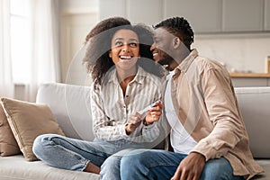 black millennial couple celebrating positive pregnancy test result at home
