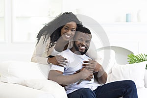 Black Millennial Couple Smiling And Posing To Camera At Home