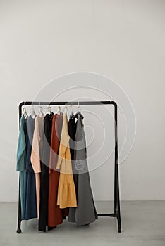 Black minimalistic rack with eco linen clothes on white background.
