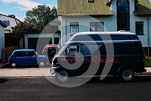 Black minivan with airbrushing in profile on a street in summer on a sunny day photo