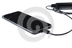 Black mobile phone and charger isolated on white background.Copy space