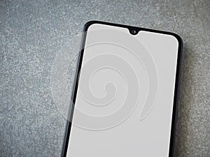 Black mobile smartphone mockup lies on the surface with a blank screen isolated on a porcelain granite ceramic stone background