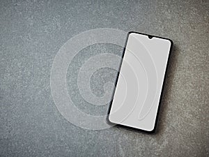 Black mobile smartphone mockup lies on the surface with a blank screen isolated on a porcelain granite ceramic stone background