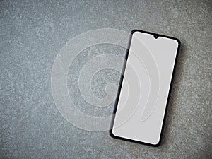Black mobile smartphone mockup lies on the surface with a blank screen isolated on a porcelain granite ceramic stone background