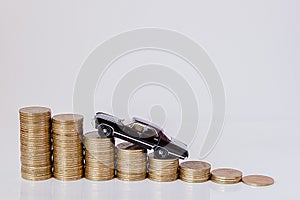 A black model of a car with coins in the form of a histogram on a white background. Concept of lending, savings, insurance
