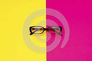 Black modern eye glasses on red and yellow background