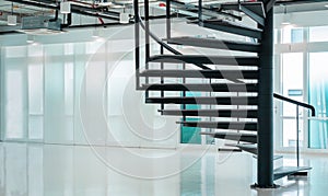 Black modern spiral stair in business office with window cityscape view background and copy space, contemporary interior floor