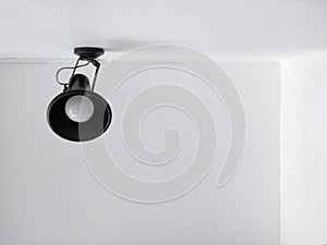 Black modern wall lamp on white cement wall with ceiling in home office room