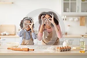 Black mom and daughter playing in the kitchen