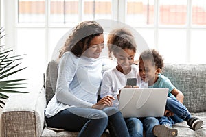 Black mom have fun with kids using gadgets at home