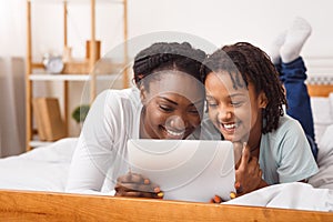 Black mother and daughter making video call to dad