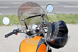 Black moto helmet on motorcycle handlebars