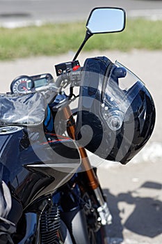 Black moto helmet on motorcycle handlebars