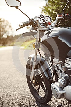 Black motorcycle on road over nature background