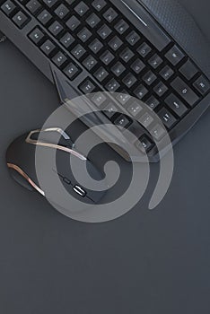 Black mouse, keyboard isolated on a dark background, top view. Flat lay gamer background