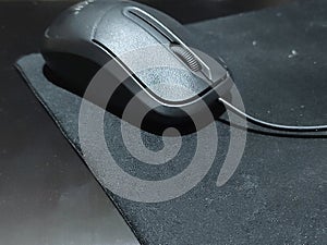 A black mouse with a mousepad on it