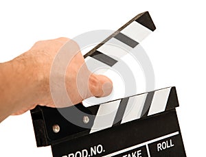 Black movie clapper with white inscriptions in the hand on a white table