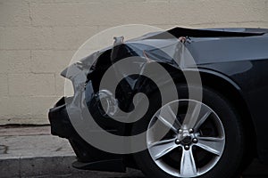 Black muscle car with a smashed front end