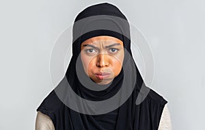 Black muslim woman in hijab pouting, frowning and looking at camera